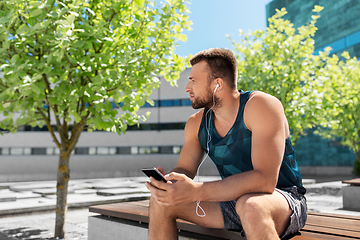 Image showing young athlete man with earphones and smartphone