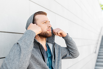 Image showing man in earphones listening to music outdoors