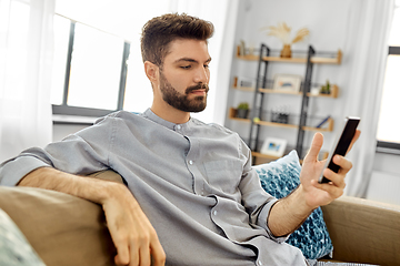 Image showing young man with smartphone at home