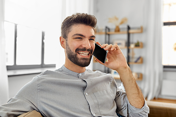 Image showing happy man calling on smartphone at home