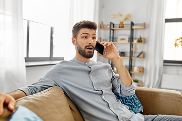 Image showing man calling on smartphone at home