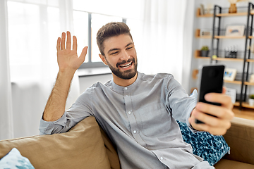 Image showing man with smartphone having video call at home