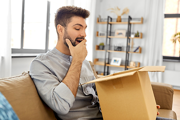 Image showing happy smiling man with open parcel box at home