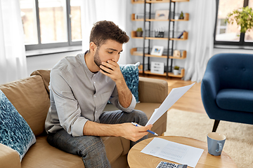 Image showing stressed man with bills at home