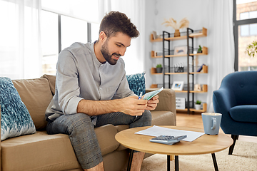 Image showing man with money and calculator filling papers