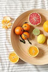 Image showing close up of citrus fruits on wooden plate