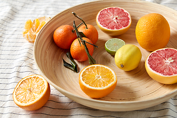 Image showing close up of citrus fruits on wooden plate