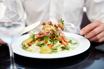 Image showing close up of man eating food at restaurant