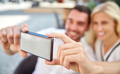 Image showing happy couple taking selfie with smatphone at cafe