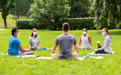 Image showing group of people sitting on yoga mats at park