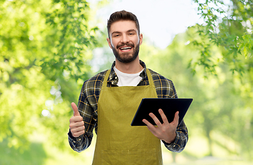 Image showing happy male gardener or farmer with tablet pc