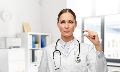 Image showing female doctor holding medicine pill at hospital