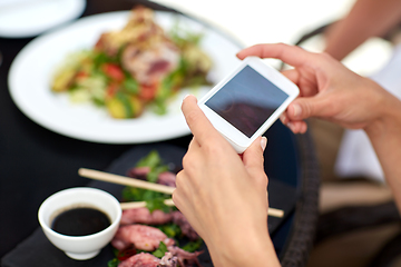 Image showing couple with smatphone photographing food