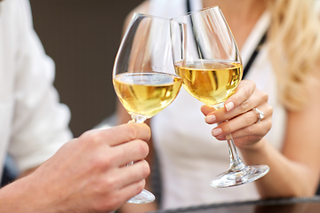 Image showing close up of couple clinking wine glasses