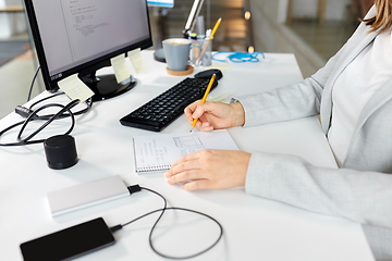 Image showing businesswoman with notebook and computer at office