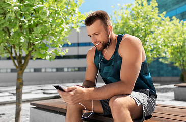 Image showing young athlete man with earphones and smartphone