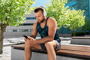 Image showing young athlete man with headphones and smartphone