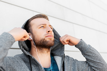 Image showing man in earphones listening to music outdoors