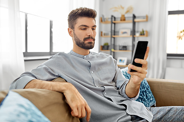 Image showing young man with smartphone at home