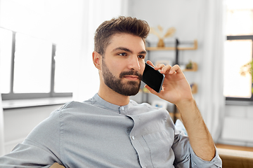 Image showing man calling on smartphone at home