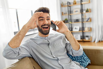 Image showing happy man calling on smartphone at home