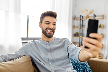 Image showing man with smartphone having video call at home