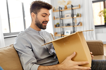 Image showing happy smiling man with open parcel box at home