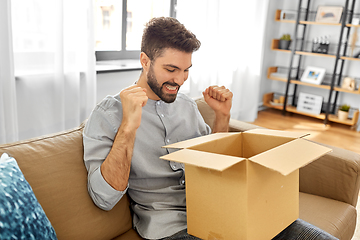 Image showing happy smiling man with open parcel box at home