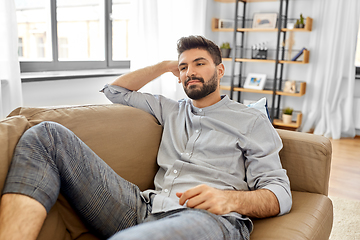 Image showing young man lying on sofa at home