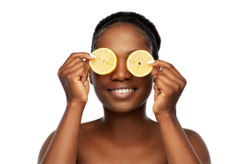 Image showing african american woman making eye mask of lemons