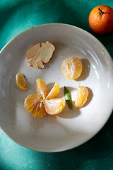 Image showing still life with peeled mandarins on plates