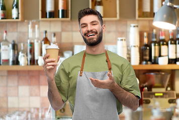 Image showing happy smiling barman in apron with takeaway coffee