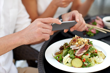 Image showing couple with smatphone photographing food