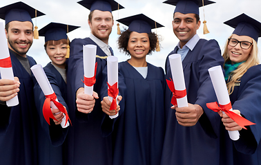 Image showing graduate students in mortar boards with diplomas