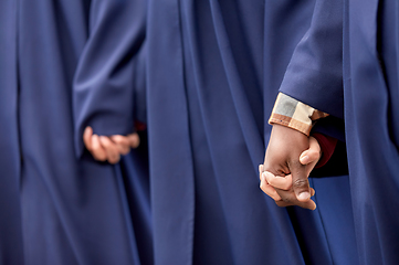 Image showing close up of graduate students holding hands