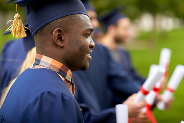 Image showing graduate students in mortar boards with diplomas