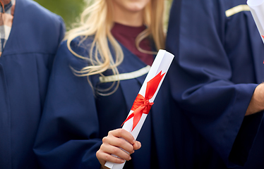 Image showing graduate students in mortar boards with diplomas