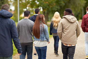 Image showing happy friends walking along autumn park