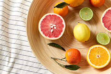 Image showing close up of citrus fruits on wooden plate