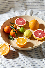 Image showing close up of citrus fruits on wooden plate