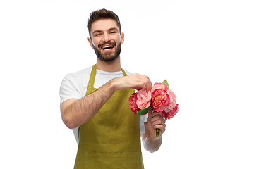 Image showing smiling male gardener with bunch of peony flowers