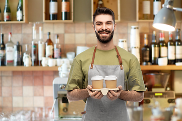 Image showing happy smiling barman in apron with takeaway coffee