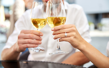 Image showing close up of couple clinking wine glasses