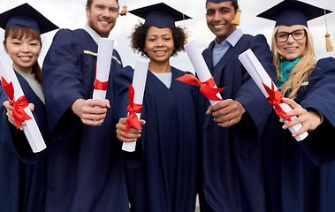 Image showing graduate students in mortar boards with diplomas