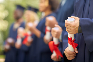 Image showing graduate students in mortar boards with diplomas