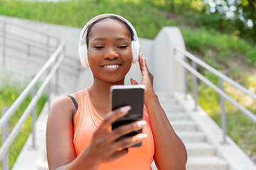 Image showing african american woman with headphones and phone