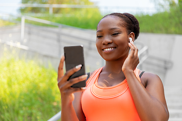 Image showing african american woman with earphones and phone