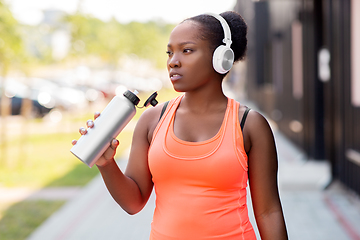 Image showing african american woman drinking water after sports