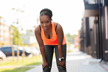 Image showing tired african american woman with earphones