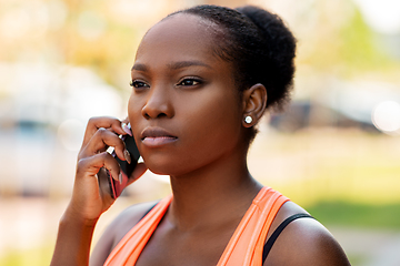 Image showing sporty african woman calling on smartphone in city